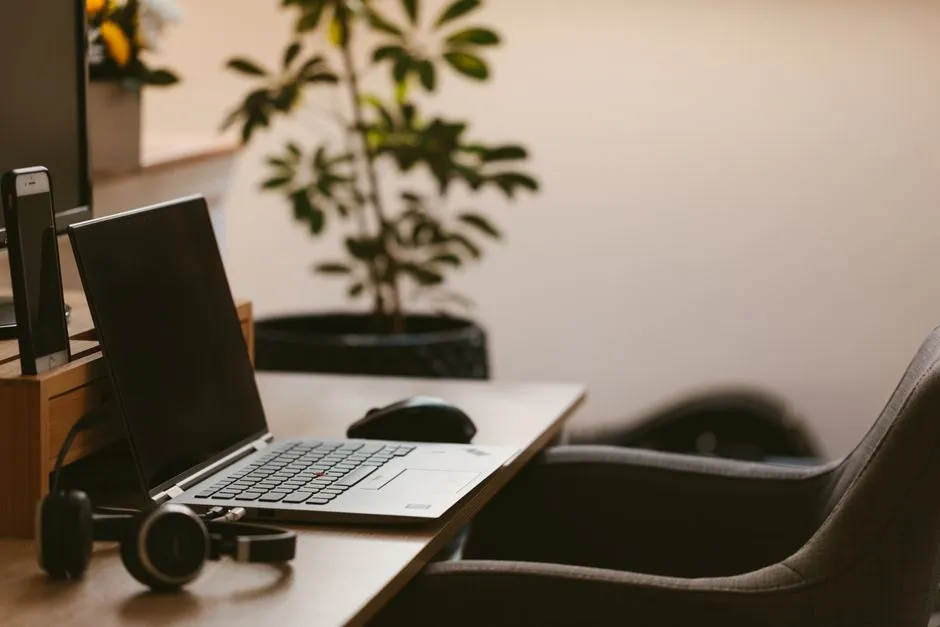 Laptop and headphones set up on a home workspace table